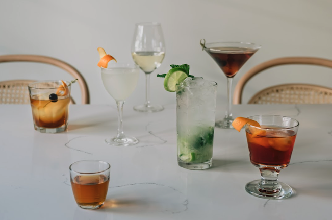 Assortment of craft cocktails in scotch, wine, and martini glasses. 