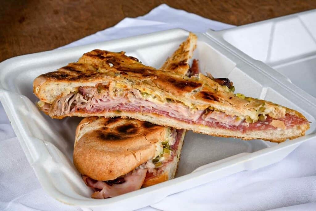 A pressed a Cuban sandwich on charred bread in a basket. 